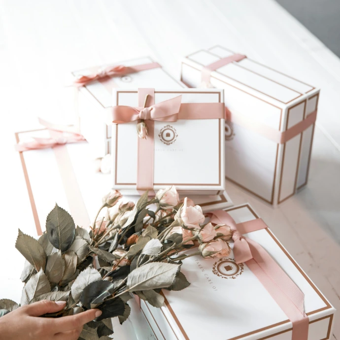 Corporate Gift boxes with pink ribbon and roses containing handmade artwork from India, perfect for employees and executives, finalizing deals.